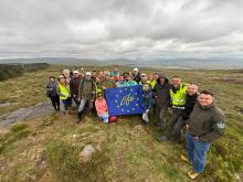 LIFE Multi Peat partners holding a LIFE flag on a restoration site